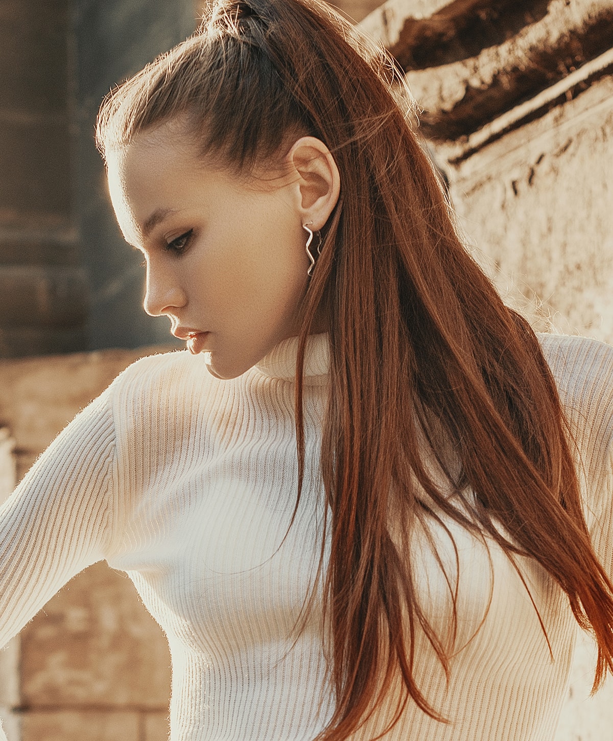 Profile of a woman with long hair and earrings.