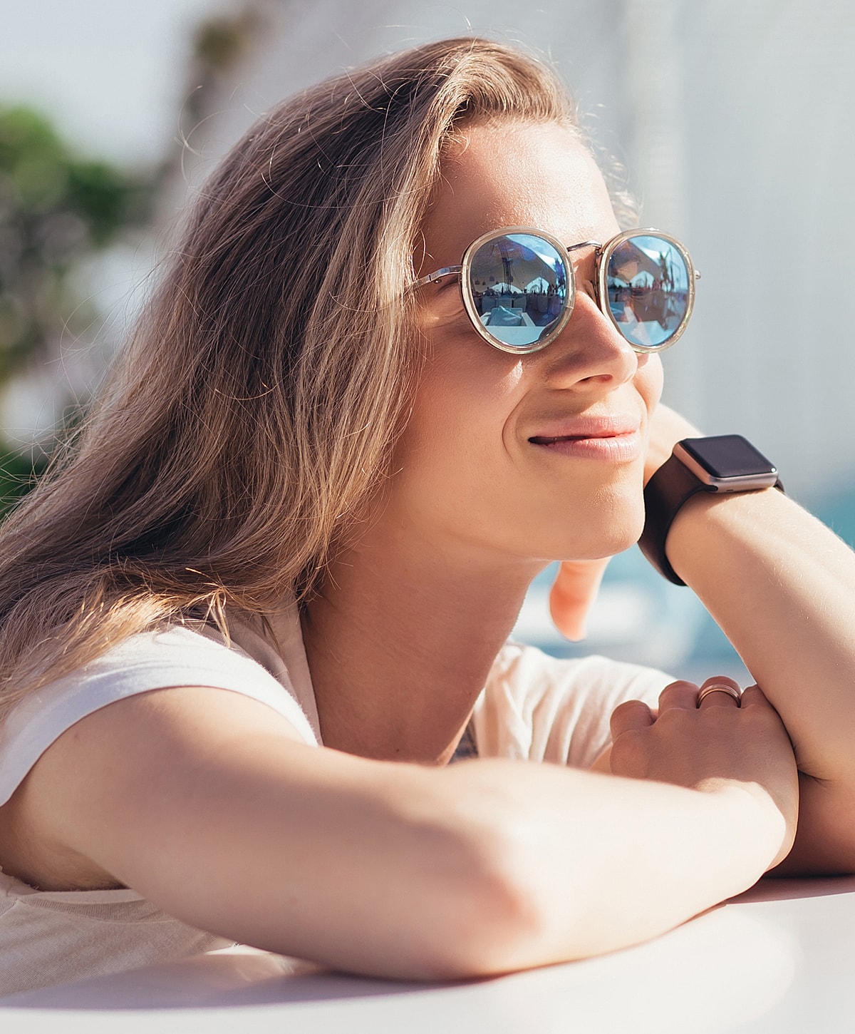Woman in sunglasses enjoying sunshine outdoors.