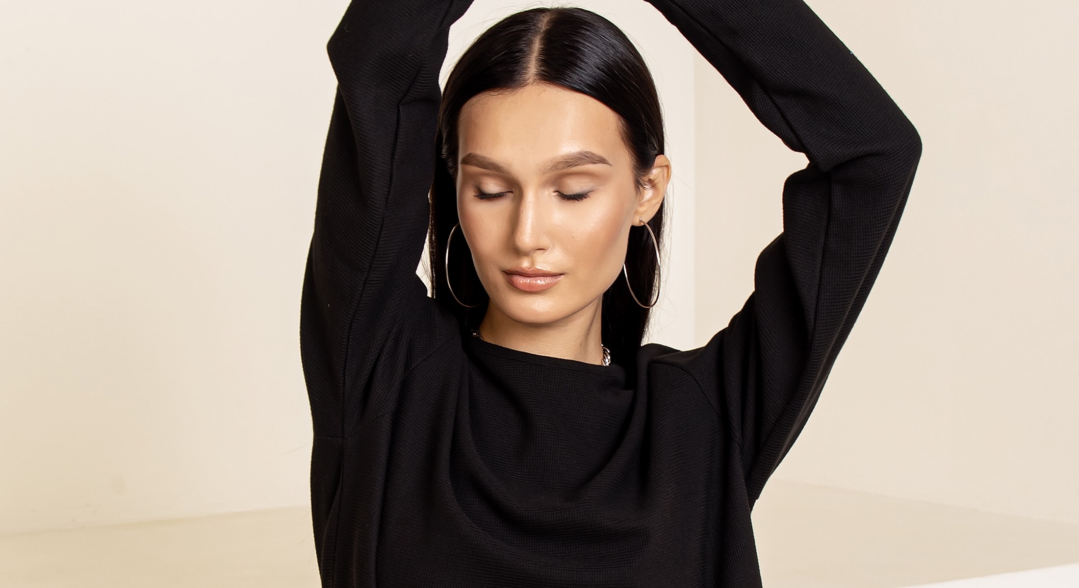 Model with closed eyes in a black sweater.