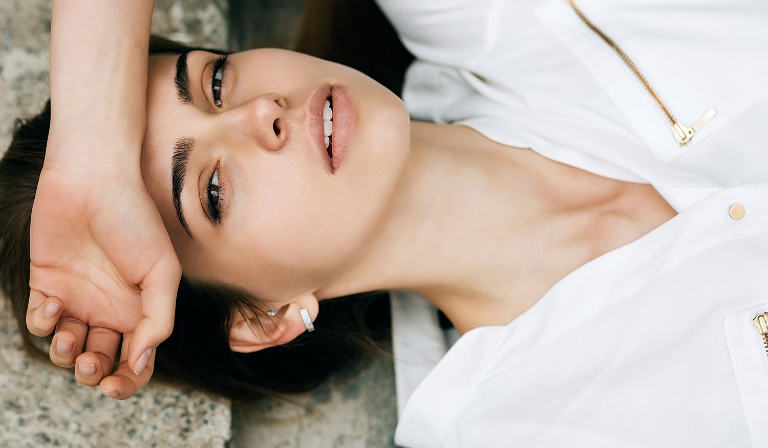 Woman with hand on forehead, relaxed expression.