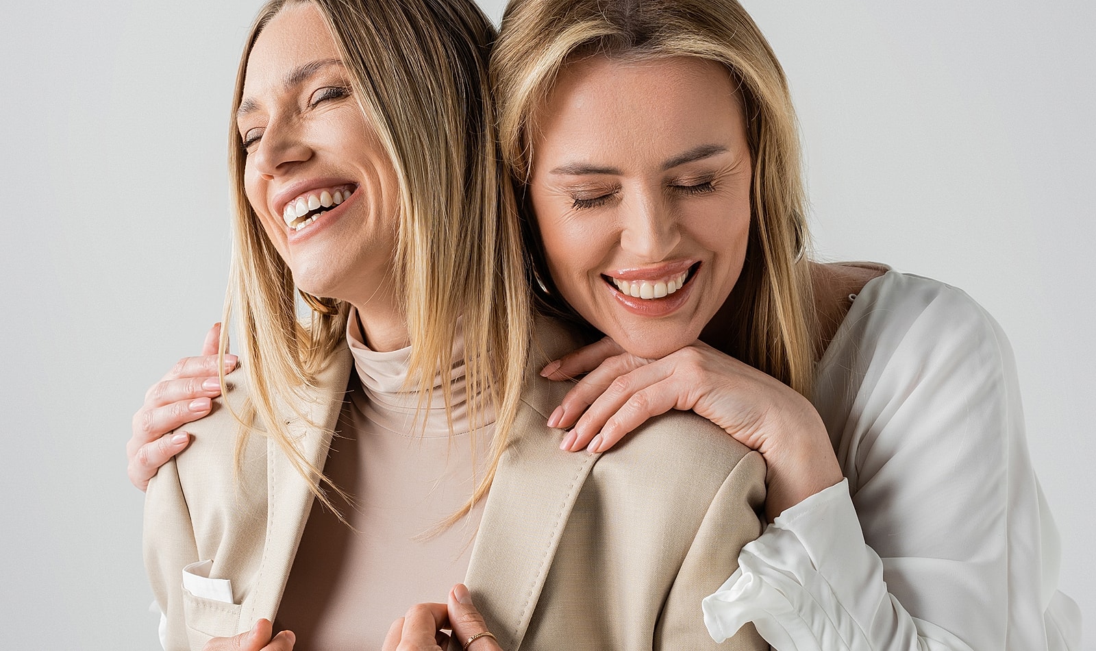 Two women smiling and sharing a joyful moment.